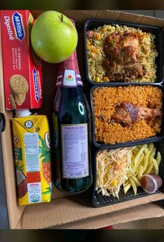 a box filled with lots of food next to an apple and some drinks on top of it