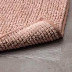 a close up view of a rug on the floor with a light pink color and texture