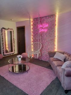 a living room decorated with pink flowers and lights on the walls, couches, coffee table and mirror