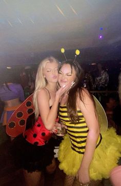 two women dressed up as ladybugs and one is kissing the other's cheek