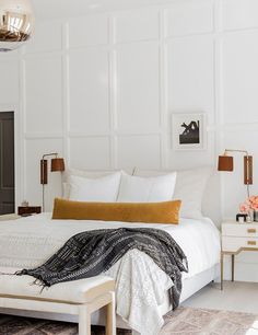 a bedroom with white walls and gold accents