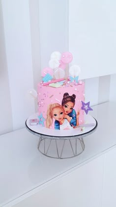 there is a cake with two girls on it and stars around the edges that are pink