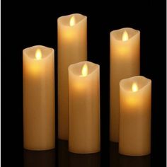 five white candles with one lit in the middle and three on each side, set against a black background