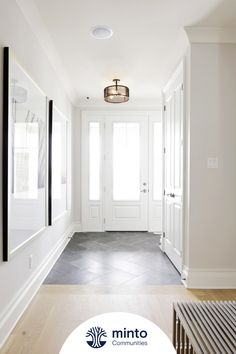 an empty hallway with white walls and wood floors