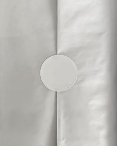 a white plate sitting on top of a table next to a sheet of silver paper