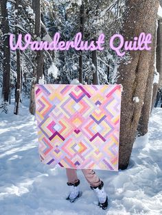 a person standing in the snow with a quilt on their back and text underneath it that reads wanderlust quilt