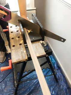 a person is working on a piece of wood with a large metal sawtoother