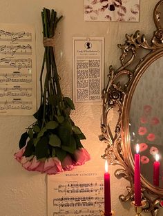 a mirror and some flowers on a wall with sheet music notes in the back ground