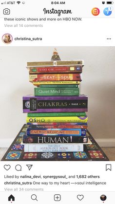 a stack of books sitting on top of each other in front of a white wall