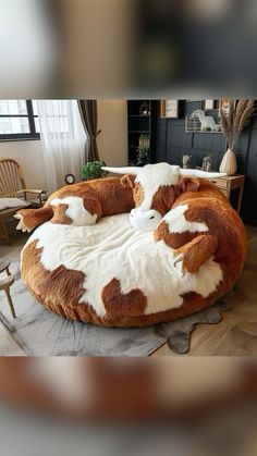 two stuffed cows laying on top of a round bed