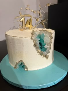 a white cake with blue frosting and gold decorations