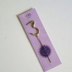 a purple and gold colored flower on top of a piece of paper with the word tops