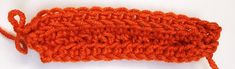 an orange crochet stitch is laying on a white surface