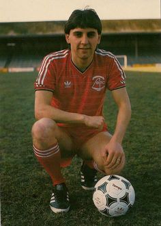 a man kneeling down next to a soccer ball