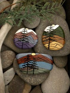 three rocks with trees painted on them