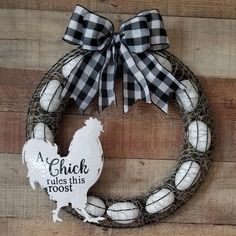 a chicken rules this toot wreath on a wooden wall with a black and white bow