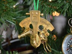 an ornament hanging from a christmas tree with scissors and compasses on it