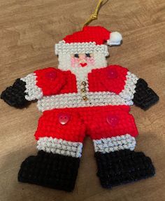 a crocheted santa clause ornament hanging on a table