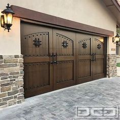 a brown garage door is shown in front of a brick wall and light fixture on the side