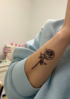 a small rose tattoo on the left inner arm and wrist is shown in black ink