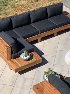 an outdoor seating area with couches, tables and potted succulents