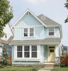 a blue house with white trim and windows on a sunny day in the suburbs of vancouver, canada