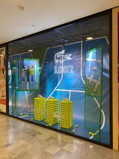 an indoor tennis court with balls and rackets on display