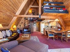 a living room filled with furniture next to a kitchen and dining area in a loft