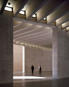 two people are walking through an empty building