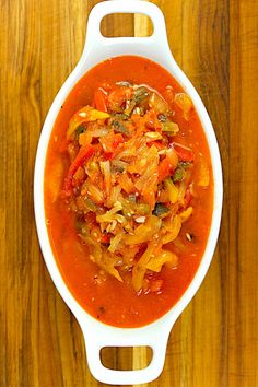 a white bowl filled with soup on top of a wooden table