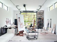 an artist's studio with lots of art work on the walls and in the floor