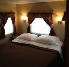 a bed with pillows and two lamps on either side