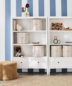 a white bookcase with blue and white striped walls in a child's room