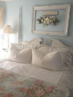 a bed with white linens and pillows in a blue room next to a window