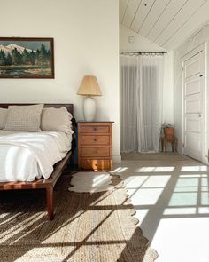 a bedroom with white walls and wooden furniture