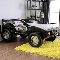 a black truck bed sitting on top of a wooden floor next to a desk and chair