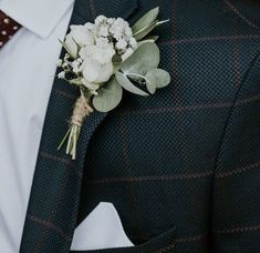 a man wearing a suit and tie with a boutonniere on his lapel