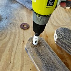 a driller that is on top of a piece of wood next to a hole in the floor