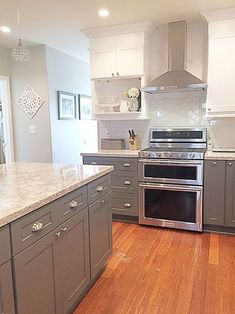 a large kitchen with stainless steel appliances and wood flooring is pictured in this image