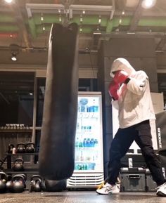 a man standing next to a punching bag in a gym