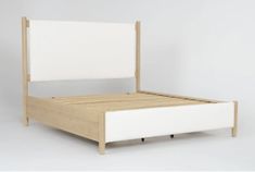 a white bed with wooden frame and headboard