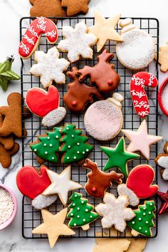 a cooling rack filled with christmas cookies on top of a table