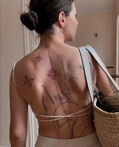 a woman with tattoos on her back holding a basket