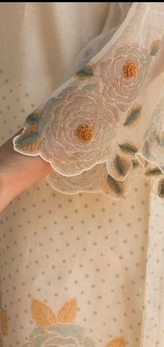 a close up of a person's hand holding an object with flowers on it