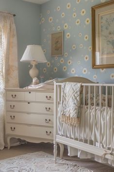 a baby's room with blue walls and white furniture