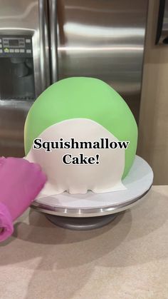 a green and white cake with the words squishmalow cake written on it