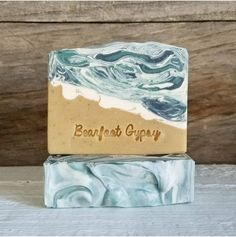 two soap bars sitting next to each other on top of a wooden table with the words earth's gravy written on it