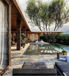 an outdoor swimming pool with lounge chairs and trees in the background, surrounded by greenery