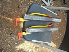 three pairs of pliers sitting on top of a black table next to some yellow and orange handles