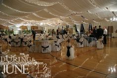 a banquet hall with tables and chairs covered in white cloths